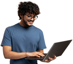 A person wearing glasses and a blue t-shirt is smiling while using a laptop.